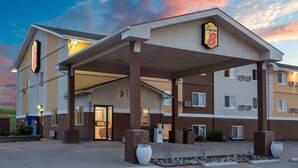 A Super 8 hotel with a covered entrance, a parking lot, and a clear sky. - Super 8 by Wyndham Gillette (Gillette)