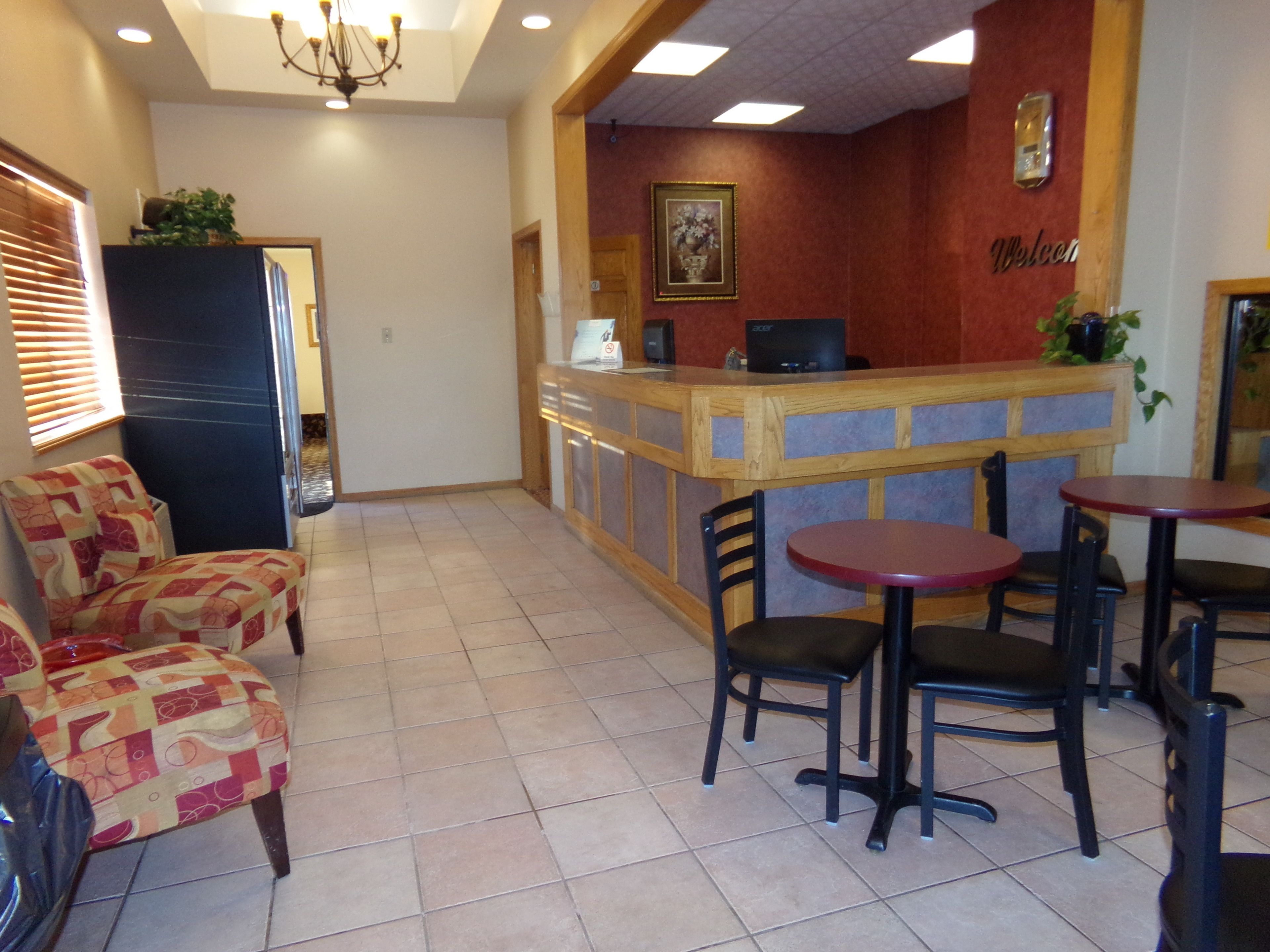 A restaurant with a wooden counter, chairs, and a reception desk.