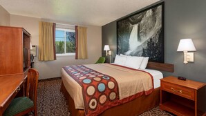 A hotel room with a bed, a desk, a chair, a nightstand, and a large painting on the wall. - Super 8 by Wyndham Gillette (Gillette)