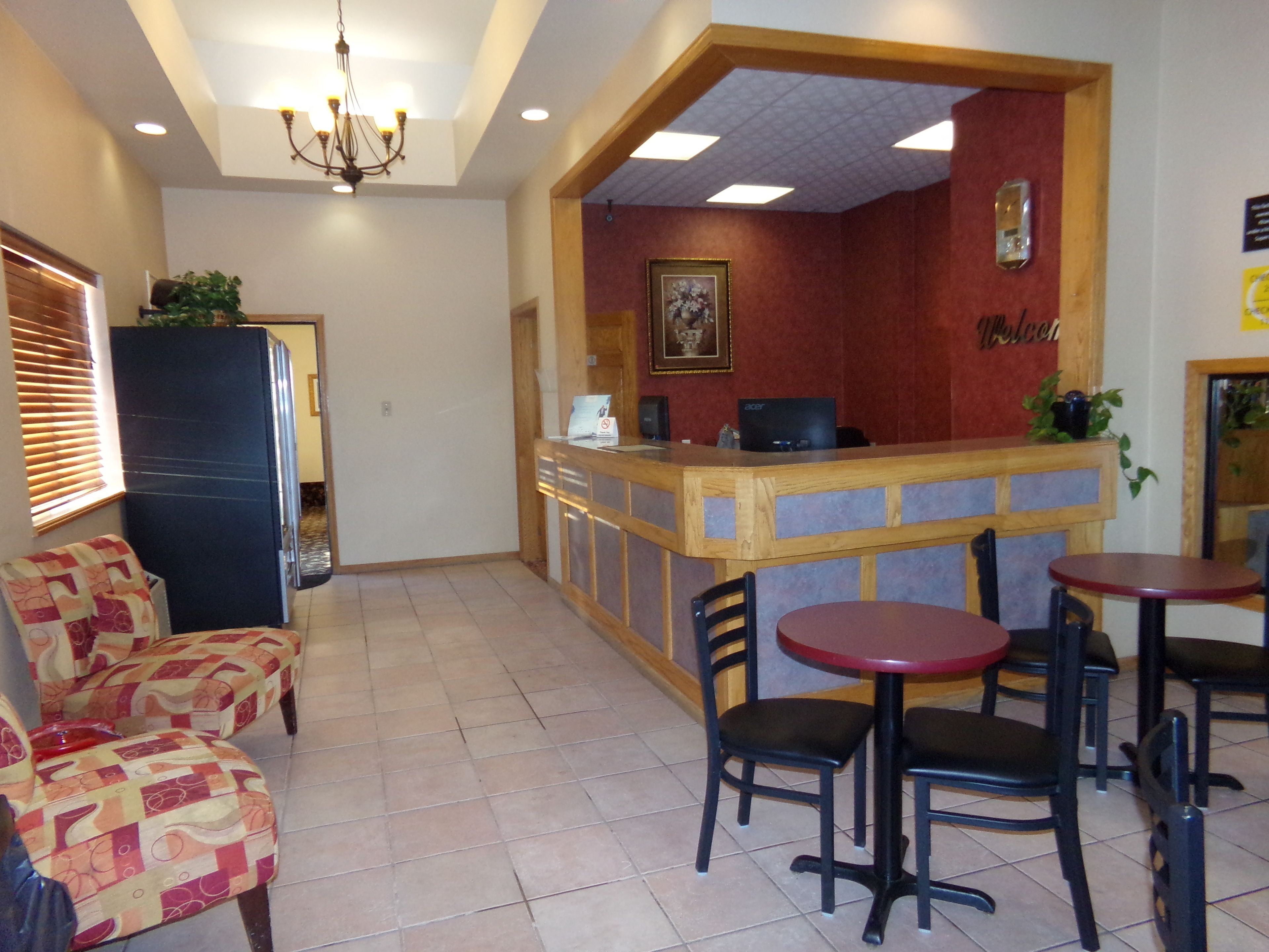 A restaurant with a counter, chairs, and a patterned sofa.