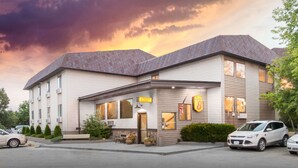 A two-story building with a 'Lobby' sign, a 'BBQ' sign, and a parking lot with cars.