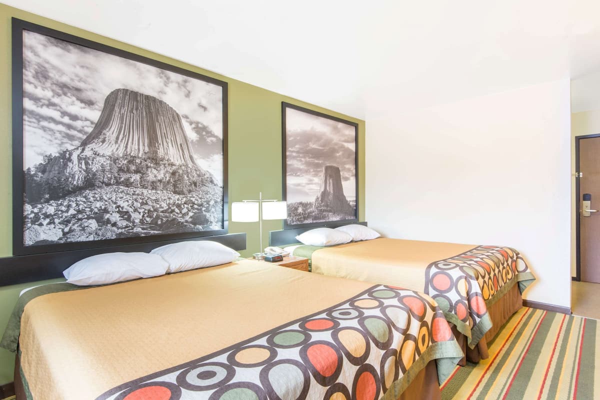 Ein Hotelzimmer mit zwei Betten, einem großen Fenster und Bergblick.