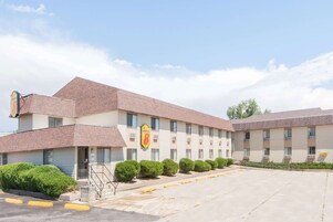 Un motel Super 8 con fachada de ladrillo, varias ventanas y un estacionamiento.