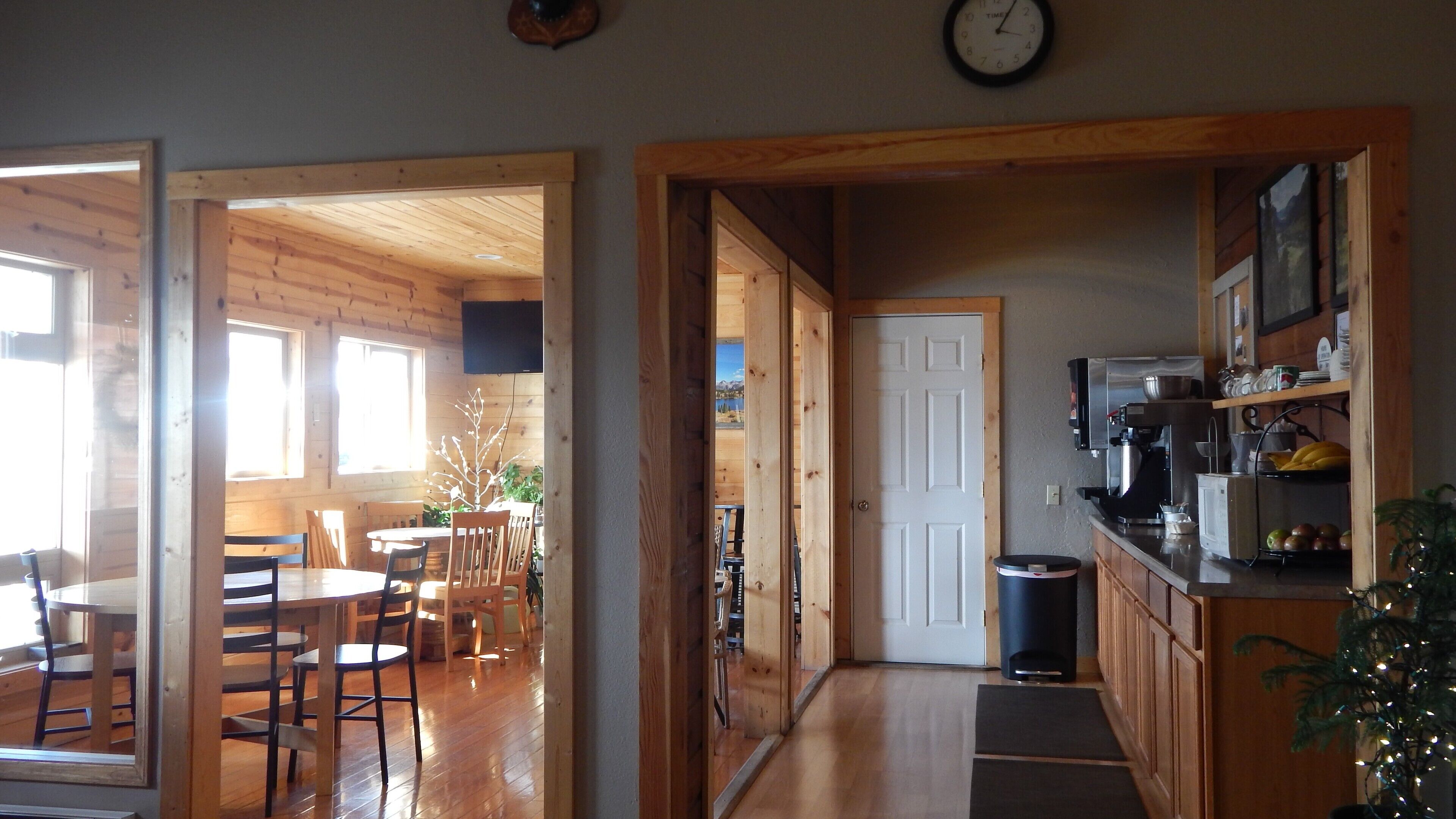 Un interior de madera con comedor, cocina y vistas al exterior.
