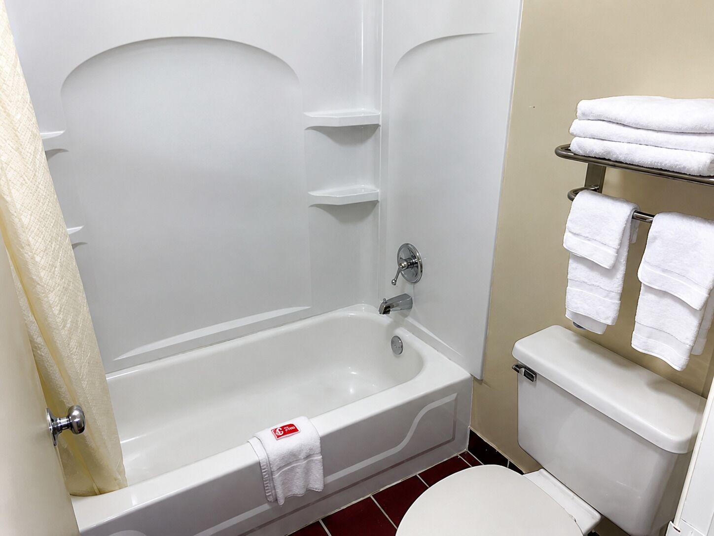 Une salle de bain avec une baignoire, des toilettes et un porte-serviettes.