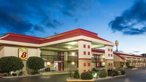 A Super 8 motel with a red roof, multiple balconies, and a parking lot.