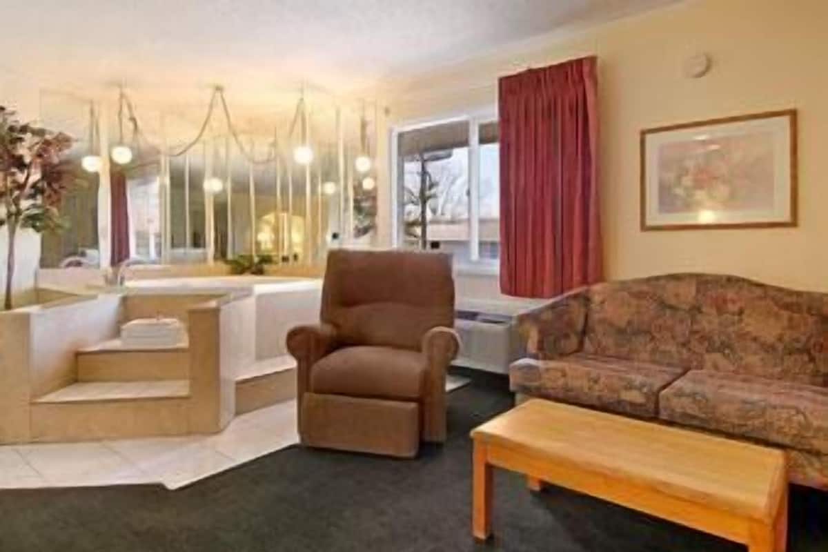 Een woonkamer met een bank, fauteuil en een houten salontafel.