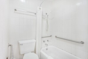 Un baño blanco con inodoro, bañera y ducha.