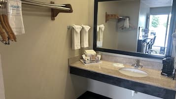 Une salle de bain équipée d’un lavabo, d’un miroir, d’un porte-serviettes et d’un panneau indiquant les services de blanchisserie.