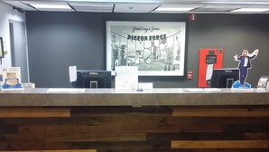 A reception desk with a wooden panel design, a framed welcome sign, and a Dell computer station. - Super 8 by Wyndham Pigeon Forge Dollywood Lane (Pigeon Forge)