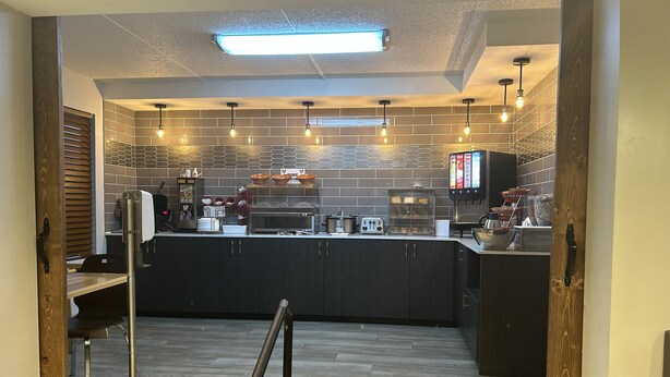 A modern kitchen with a central island, a coffee machine, and a menu board. - Super 8 by Wyndham Pigeon Forge Dollywood Lane (Pigeon Forge)