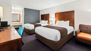 A hotel room with two beds, a desk, a chair, and a TV. - Rodeway Inn Dalton South (Dalton)