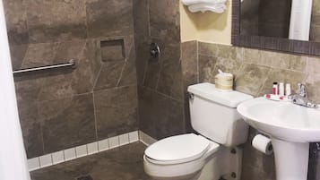 A bathroom with a shower, toilet, and sink.