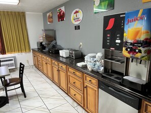 A kitchen with a coffee machine, toaster, and a juice dispenser. - Super 8 by Wyndham Park City/North Wichita Area (Wichita)