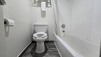A bathroom with a toilet, a shower, and a towel rack.