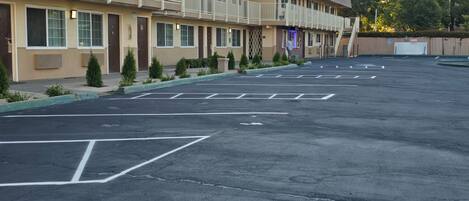 A motel with a parking lot, multiple balconies, and a sign for a breakfast restaurant.