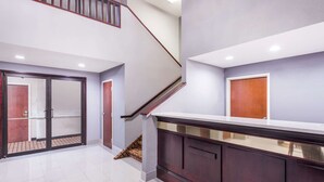 Un intérieur moderne avec un escalier, une grande armoire en bois et une porte en verre.