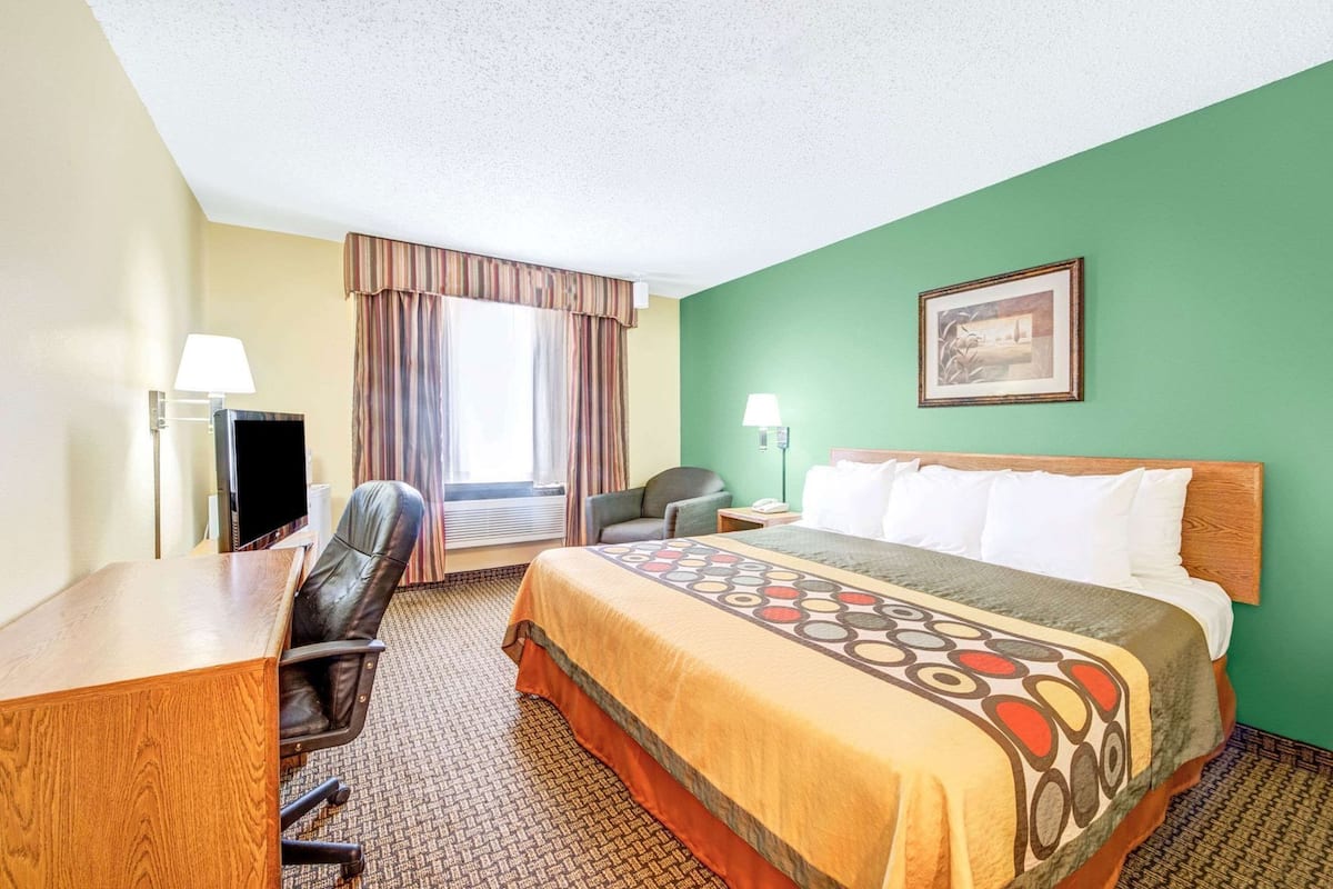Une chambre d’hôtel équipée d’un lit, d’un bureau, d’une chaise et d’un téléviseur.