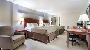 A hotel room with two beds, a desk, a chair, and a lamp. - Townhouse Inn (High Point)