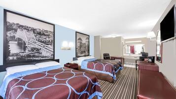 A hotel room with two beds, a desk, a chair, and a TV.