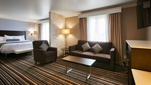 A hotel room with a bed, a sofa, a chair, a small table, and a desk. - Best Western Plus Diamond Valley Inn (Hemet)