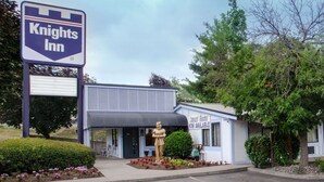 A Knights Inn with a signboard, a statue, and a building with a sign for 'Vacuum Rooms'.