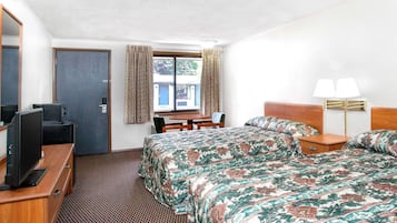 A hotel room with two beds, a desk with a chair, a television, a window with curtains, and a lamp.