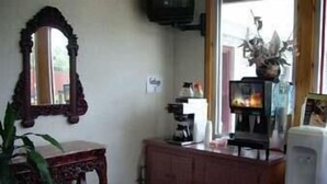Una habitación con un armario de madera, un espejo, un televisor y una planta en maceta.