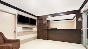 A modern room with a flat-screen TV mounted on a wall, a built-in bench, and a door. - Econo Lodge Inn & Suites Florida City (Florida City)