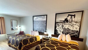 Quarto de hotel com duas camas, uma janela grande e uma pintura de um campo de girassóis.