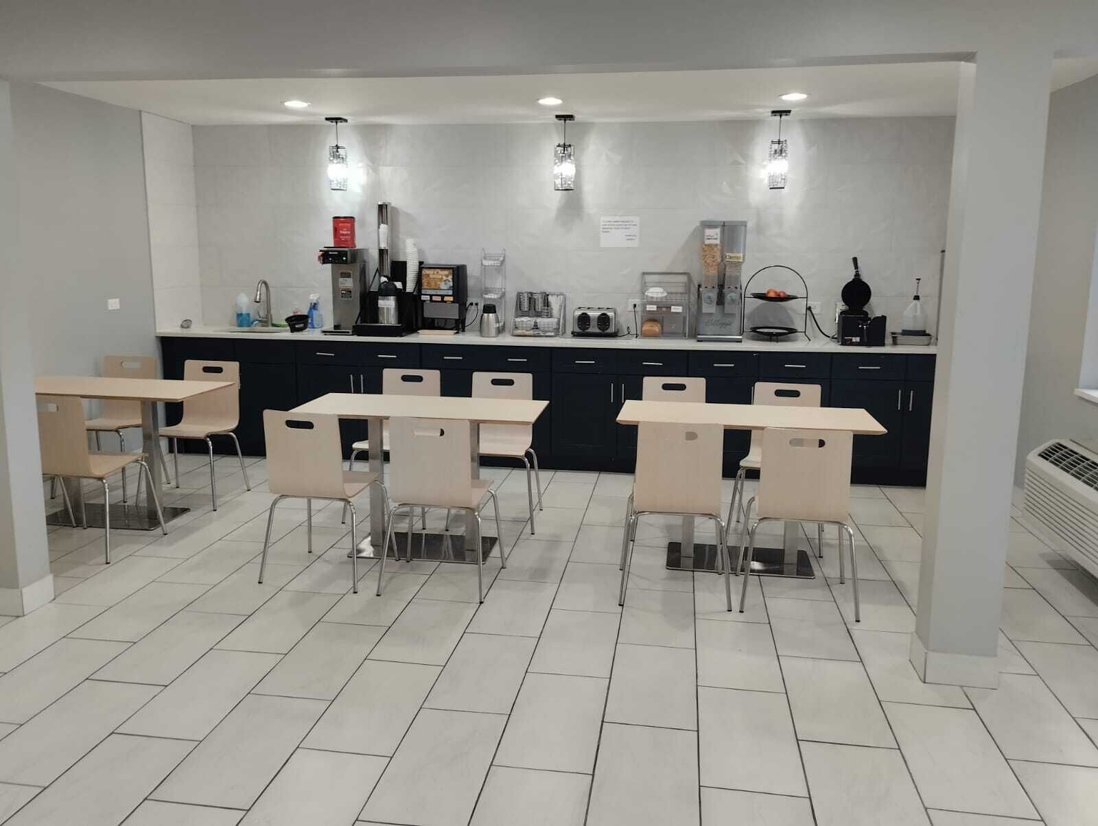 A modern kitchen with a central island, built-in appliances, and a dining area with chairs and tables.