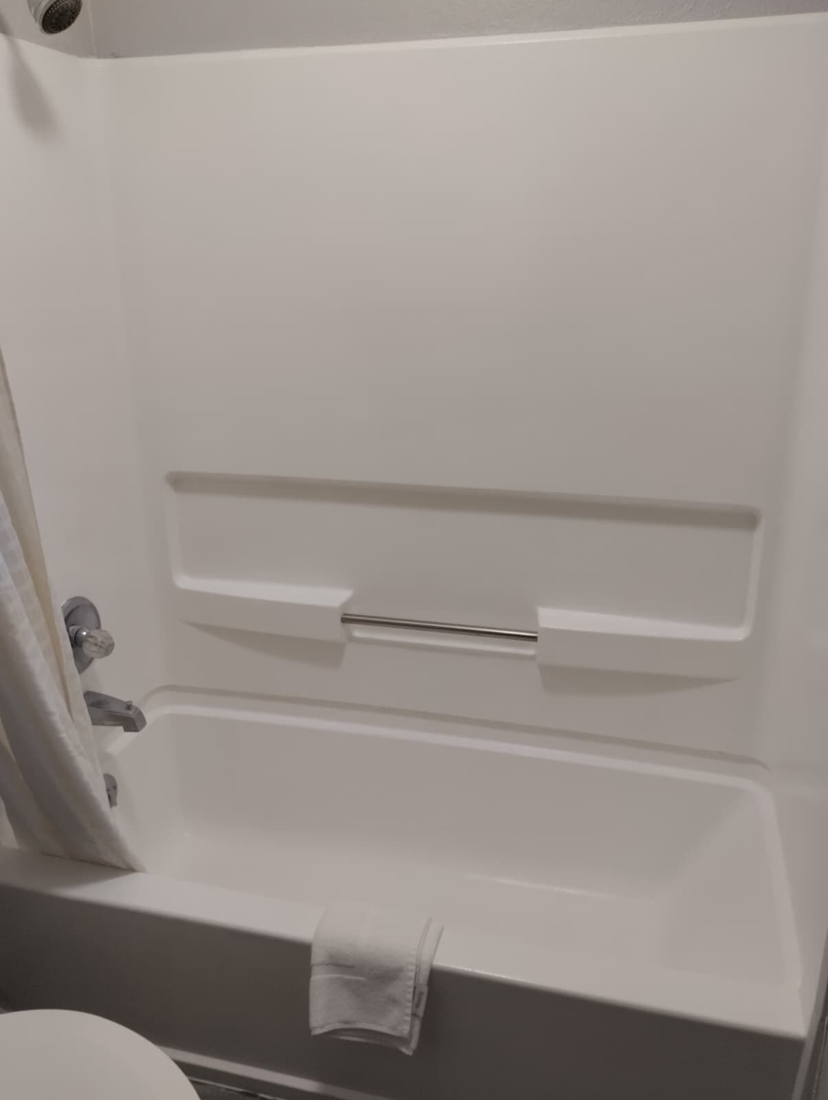 Una bañera con una toalla colgada a un lado.