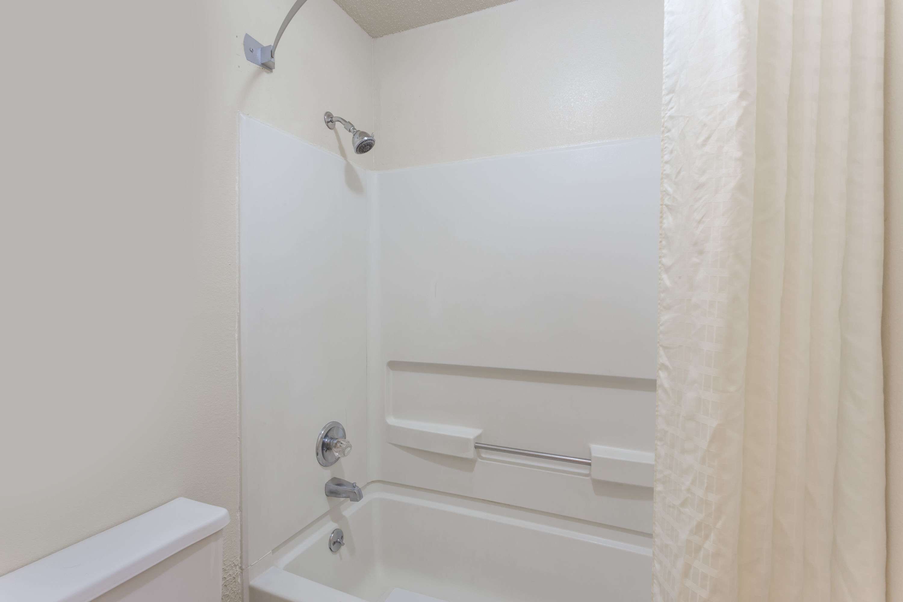 A white bathroom with a shower, a bathtub, and a toilet.