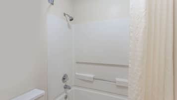 A white bathroom with a shower, a bathtub, and a toilet.