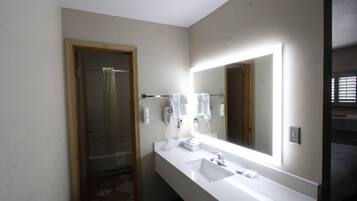A bathroom with a large mirror, white sink, and towel rack.