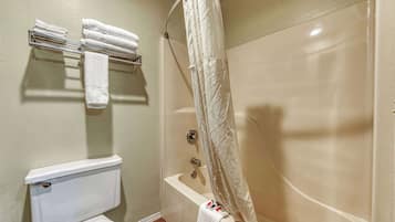 A bathroom with a toilet, a bathtub, and a towel rack with towels.