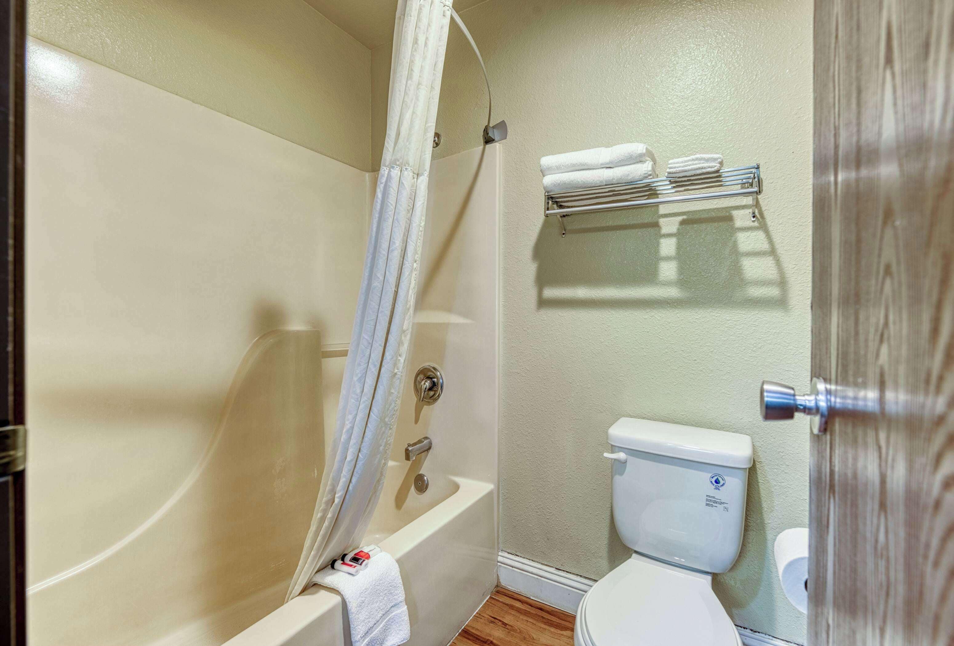 A bathroom with a bathtub, toilet, and a towel rack.
