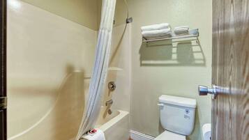 A bathroom with a bathtub, toilet, and a towel rack.