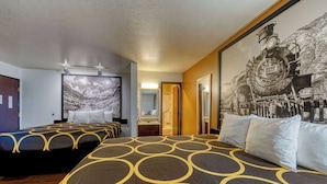 Een hotelkamer met twee bedden, een groot schilderij van een trein en uitzicht op de bergen.