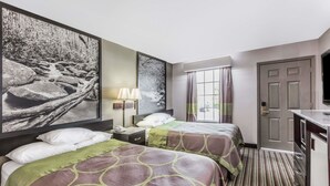 Habitación de hotel con dos camas, un escritorio, una lámpara y un ventanal con cortinas.