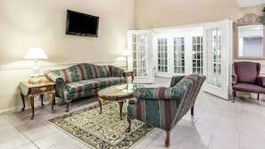 A living room with a sofa set, a coffee table, a TV, and a chair.