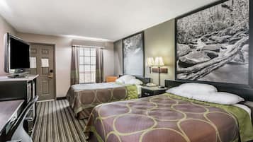 A hotel room with two beds, a desk with a TV, a window with curtains, and a large framed picture on the wall.