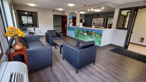 A hotel lobby with seating, a reception desk, and a large window. - Super 8 by Wyndham Paris (Paris)