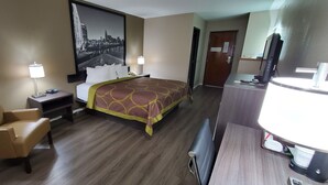 A hotel room with a bed, a desk, a chair, a television, and a large cityscape painting on the wall. - Super 8 by Wyndham Paris (Paris)