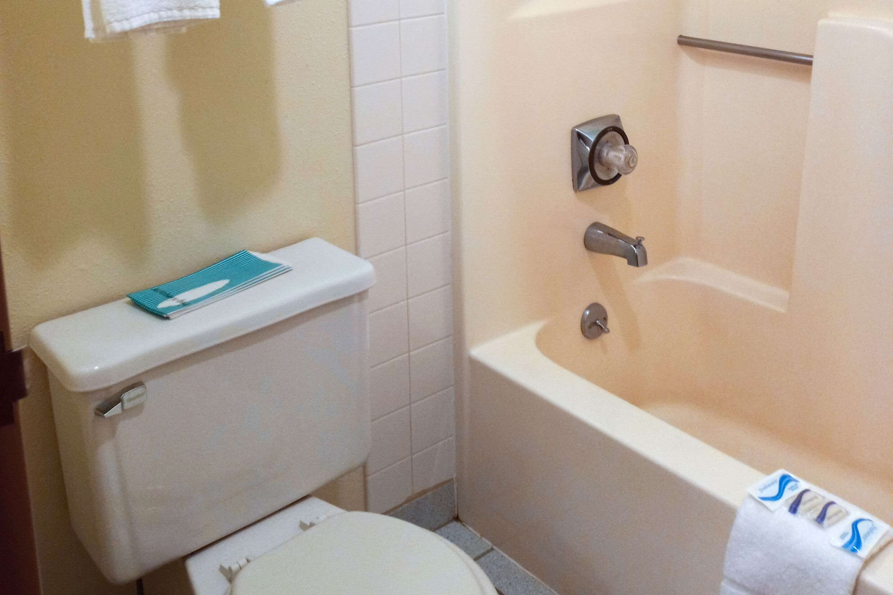 Une salle de bain équipée de toilettes, d’une baignoire et d’un porte-serviettes.
