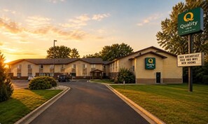 Un hôtel Quality Inn avec un panneau indiquant que le petit-déjeuner est gratuit, que le Wi-Fi HBO est offert gratuitement et que les chambres sont neuves.