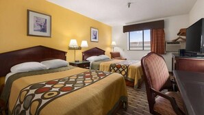 Una habitación de hotel con dos camas, un escritorio, una silla y un televisor.