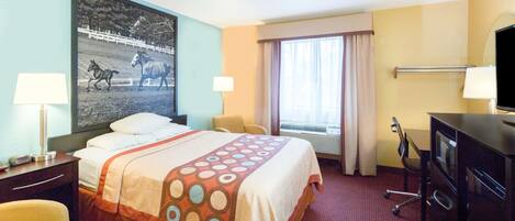 A hotel room with a bed, a desk, a chair, a TV, and a window with curtains.