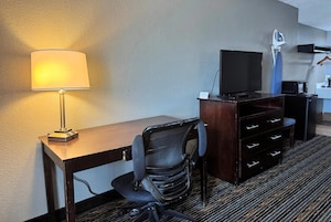 Escritorio, cortinas blackout y tabla de planchar con plancha