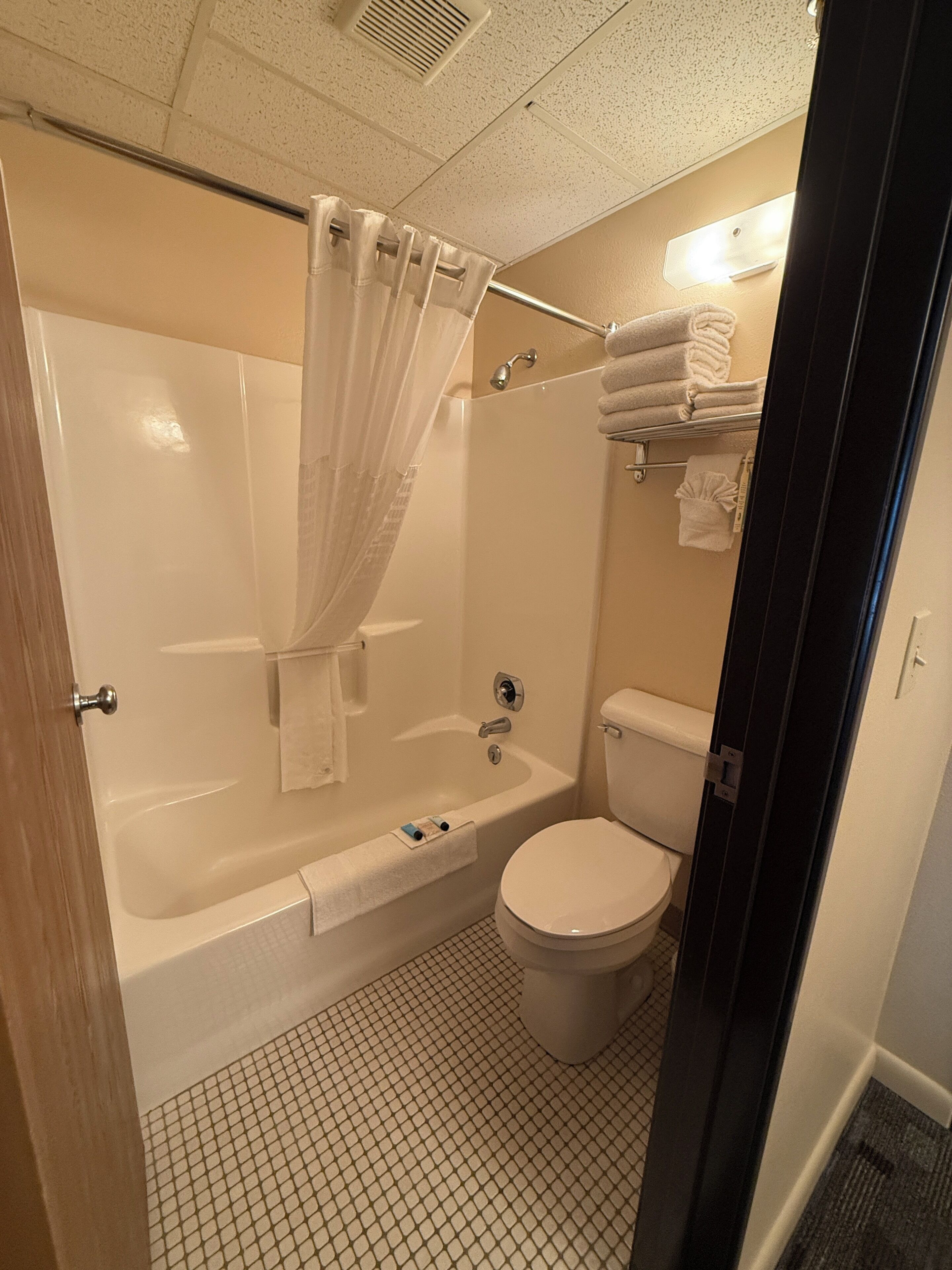 Un baño con bañera, inodoro y cortina de ducha.